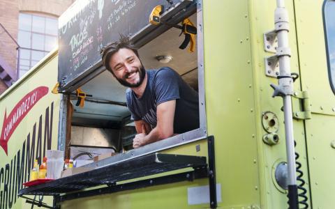 iStock-828046798.jpg Lachende ondernemer leut uit food truck